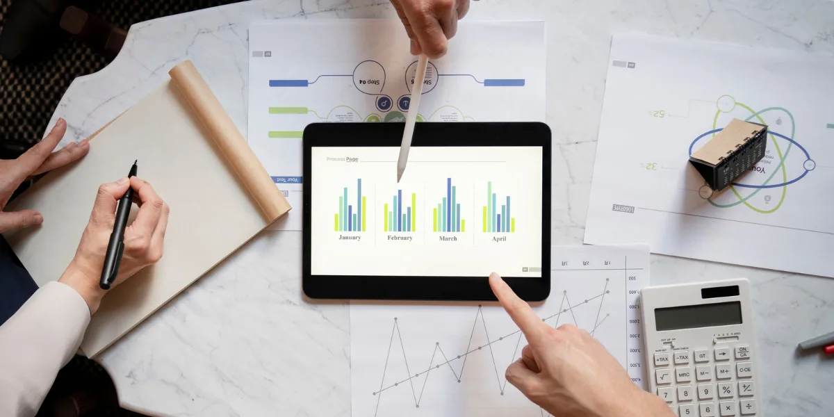 Business professionals analyzing forensic accounting data on a tablet with charts and graphs, emphasizing financial investigation and compliance.